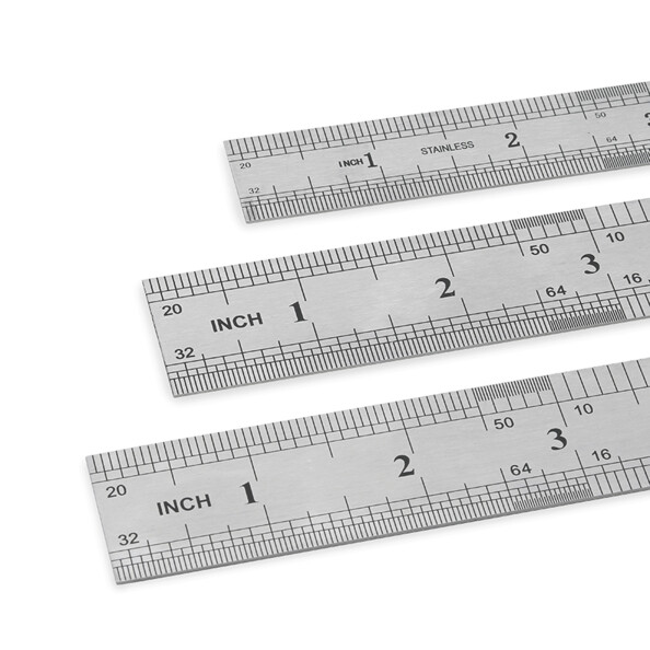 Zoom sur les graduations en pouces et centimètres des trois règles en acier inoxydable