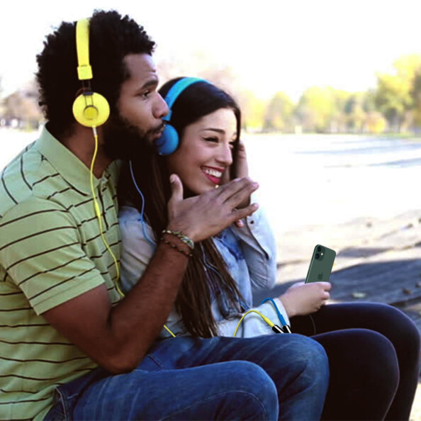 Couple homme-femme écoutant de la musique par le biais d'un smartphone et de deux casque branchés par doubleur audio stéréo