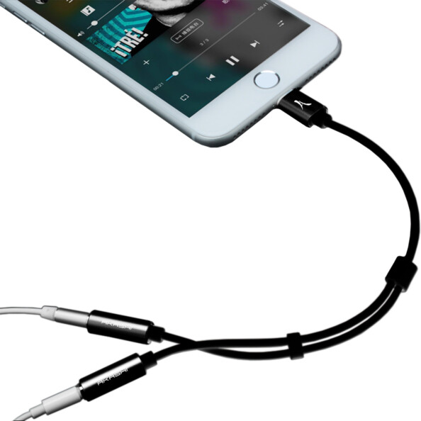 Téléphone portable Apple avec écran allumé branché à des écouteurs filaires par adaptateur Lightning vers jack