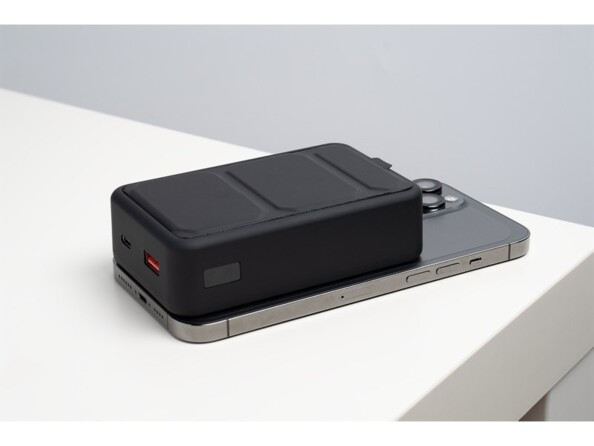 Mise en situation de la fixation magnétique de la batterie haute capacité à l'arrière d'un iPhone posé sur une table face écran