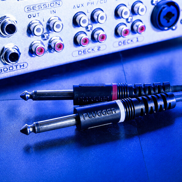 Fiches jack 6,35 mm PLUGGER avec bagues rouges et blanches sur table de mixage DJ
