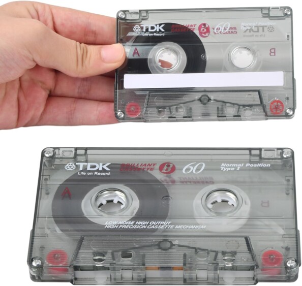 Main tenant une cassette vierge TDK B60 avec étiquette d'identification vierge