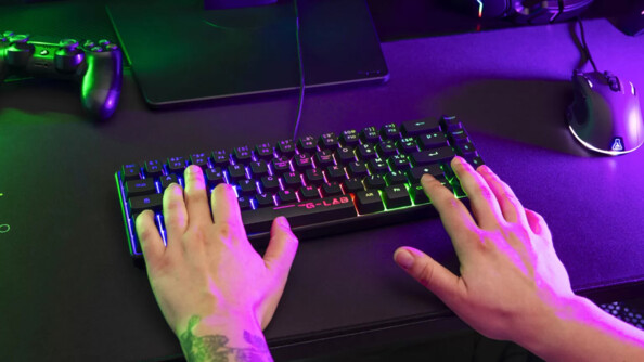 Pro gamer en cours d'utilisation du mini clavier gaming Hydrogen noir The G-Lab assis à un bureau