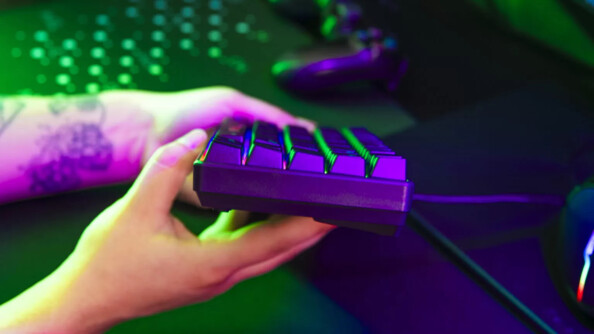 Gros plan sur l'épaisseur du clavier gamer filaire coloris noir tenu en main par une personne