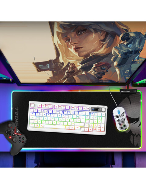 Mise en situation du clavier lumineux dans un setup gaming plongé dans le noir avec écran PC, tapis de souris et souris sans fil