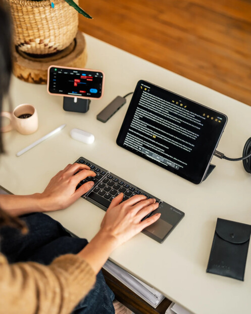 Mise en situation de l'utilisation du clavier de voyage pliable connecté à une tablette tactile faisant office d'écran de PC sur un bureau