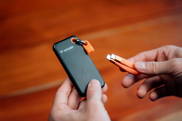 Personne tenant dans sa main gauche le disque SSD et dans sa main droite le câble USB-C