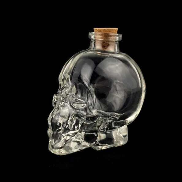 Crâne en verre transparent avec bouchon en liège disposé sur fond noir
