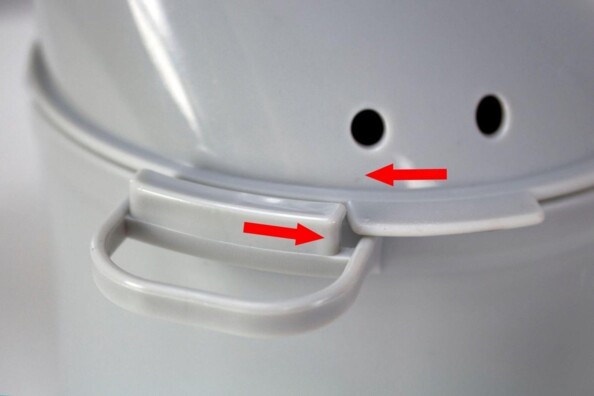 Gros plan sur la fermeture rotative de l'inhalateur coloris gris indiquée par des flèches rouges