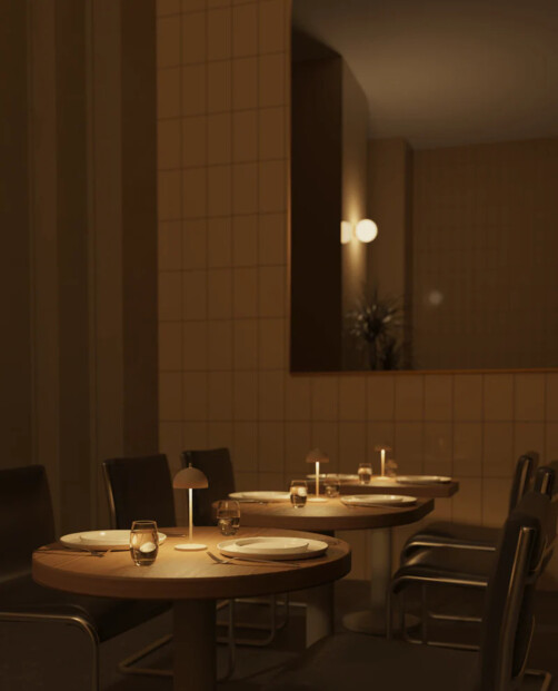 Mise en situation des lampes de table à batterie rechargeable sur des tables d'un restaurant chic à l'éclairage blanc chaud