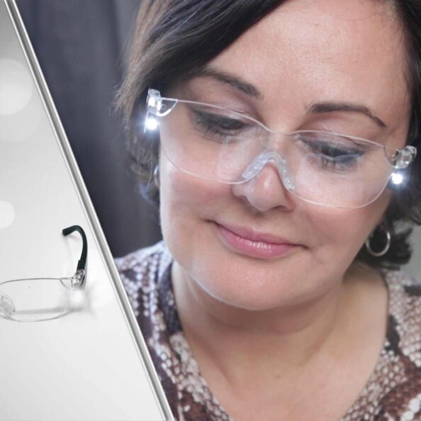 Jeune femme observant un élément vers le bas avec les lunettes loupe LED