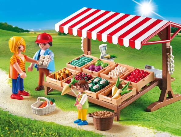 Mise en situation de l'étal de légumes sur un chemin de terre avec trois figurines en plastique Playmobil