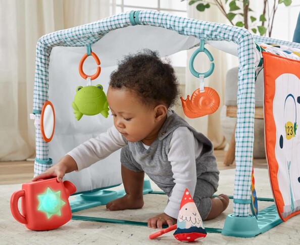 Bébé joue avec l'arrosoir avec sons et lumières du tapis cabane Fisher Price