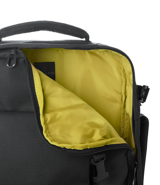 Gros plan sur un coin ouvert du sac à dos cabine avec vue sur l'intérieur vert anis/jaune du compartiment principal