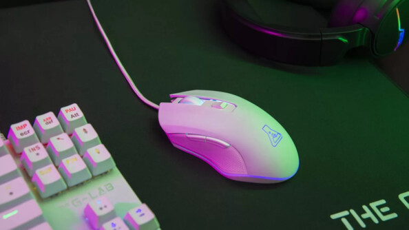 Vue de biais côté gauche de la souris Kult Helium installée dans un setup gaming lumineux personnalisé