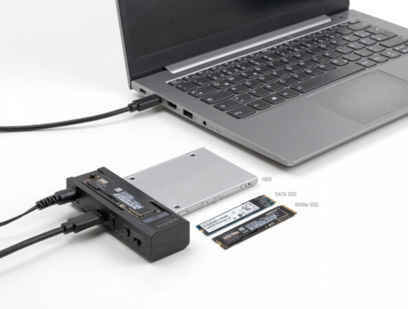 Mise en situation du hub branché à un PC portable éteint et à une alimentation externe avec disque dur HDD, SATA SSD et SSD NVme posés à côté