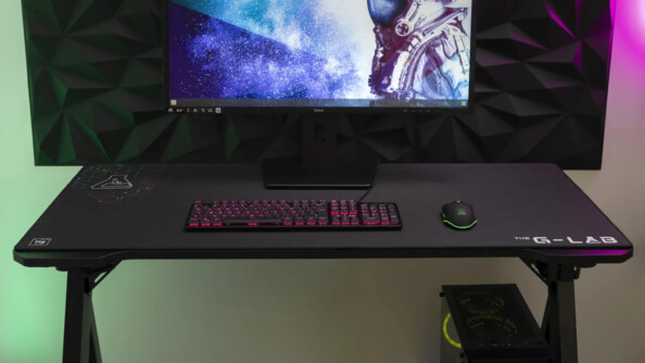 Mise en situation du pad de souris sur un bureau sous un clavier rétroéclairé, un écran PC et une souris sans fil