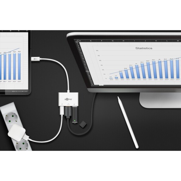 Hub multiports Goobay raccordé à un portable et une tablette sur un bureau sombre