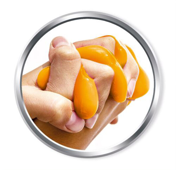 Mains malaxant du slime orange fabriqué avec le coffret Clementoni