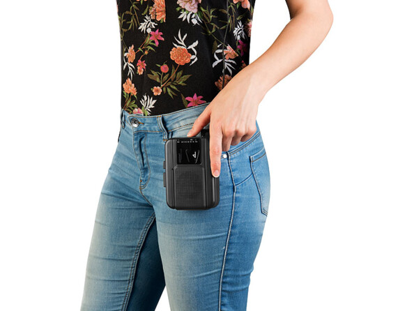 Baladeur lecteur de cassettes MCR-280 fixé par clip de transport amovible au jean d'une femme avec haut fleuri
