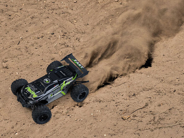 Buggy télécommandé à quatre roues motrices Mad Racing mise en situation roulant dans du sable