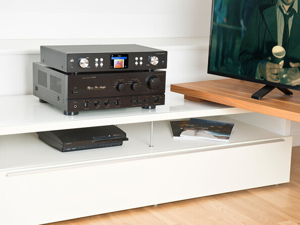 tuner hifi de salon connecté posé sur un amplificateur sur un meuble tv