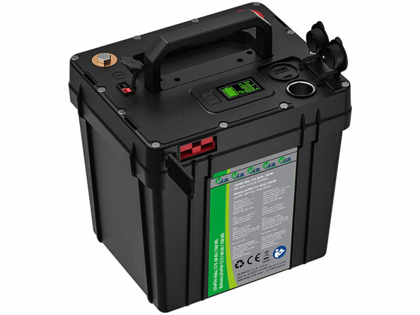 Vue plongeante sur le haut de l'accumulateur de stockage avec cache de protection des connecteurs ouverts, écran allumé, poignée relevée et consignes de sécurité à l'avant