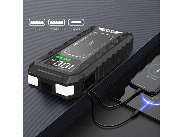 Booster pour batterie de voiture et batterie USB PB-815.kfz mis en situation sur un bureau rechargeant un smartphone et une tablette