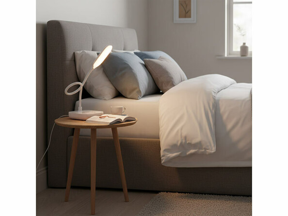 Lampe CCT rechargeable avec intensité variable mise en situation sur un chevet à coté d'un lit