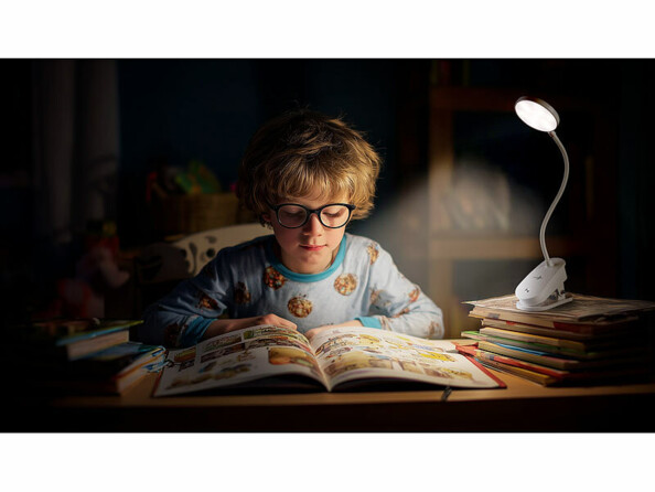 Lampe de lecture CCT rechargeable mise en situation sur un bureau avec un enfant qui lit