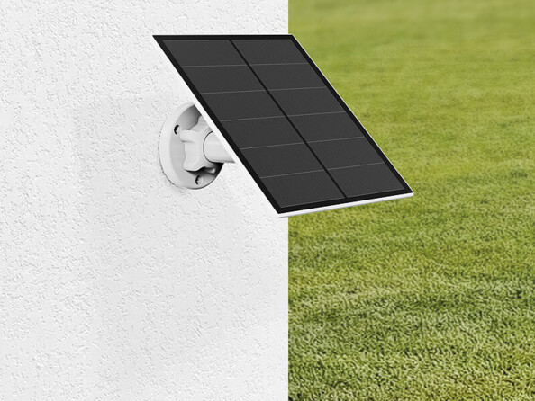 Cellule solaire fixée à une façade blanche dans un jardin par le biais de son support mural