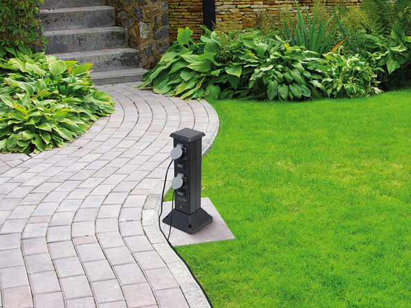 Multiprise de jardin connectée et intelligente avec 4 prises et commandes vocales mise en situation dans un jardin