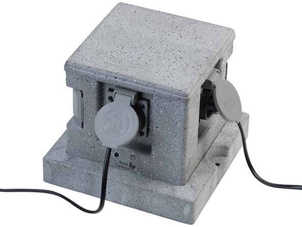 Multiprise de jardin connectée et intelligente avec 4 prises et commandes vocales aspect pierre mise en situation avec prises branchées