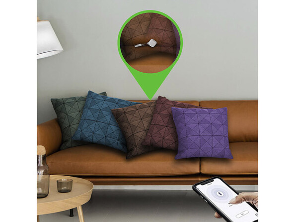 Mise en situation de la recherche d'un objet perdu dans le canapé d'un salon avec un smartphone, une application et le porte-clés siffleur