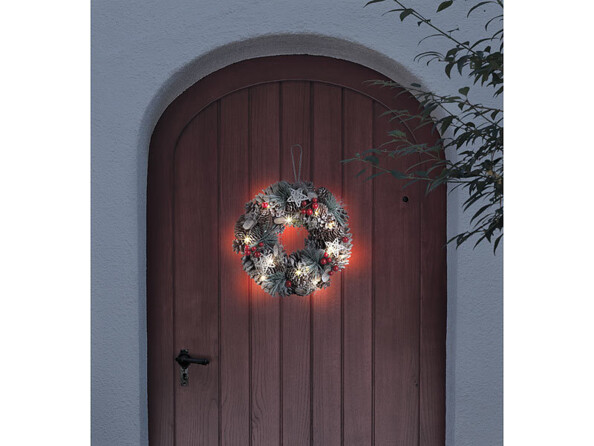 Couronne de l'Avent lumineuse de 30 centimètres de diamètre avec pommes de pin et reflets rouges.