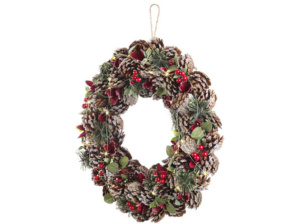 Couronne de Noël lumineuse, avec des reflets rouges décorée de branches de sapin, de baies, de feuilles vertes et de petites pommes de pin