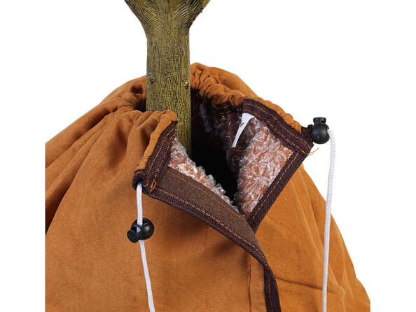 Gros plan sur la fermeture de la housse de protection installée autour d'un arbuste montrant les cordons de fermeture à longueur réglable avec leur système de blocage