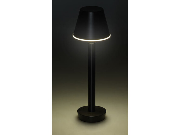 Lampe OT-310 placée sur fond noir et allumée d'une lumière blanche dans le noir