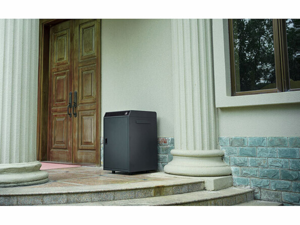 Boîte à colis en métal posée sur le sol en pierre d'une maison d'inspiration grec avec colonnes