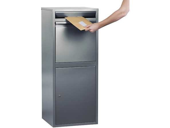 Boîte aux lettres sur pied avec dispositif anti-retour mise en situation avec une personne déposant un courrier