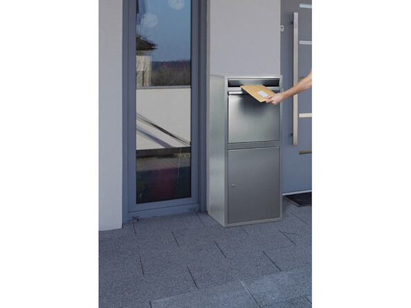 Boîte aux lettres sur pied avec dispositif anti-retour mise en situation devant une maison