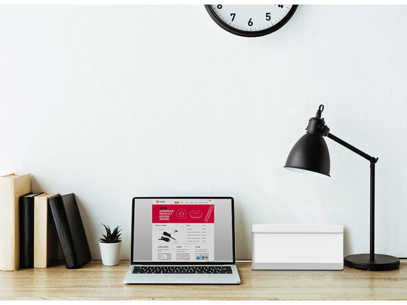 Boîte de rangement pliable pour multiprise coloris blanc mise en situation sur un bureau