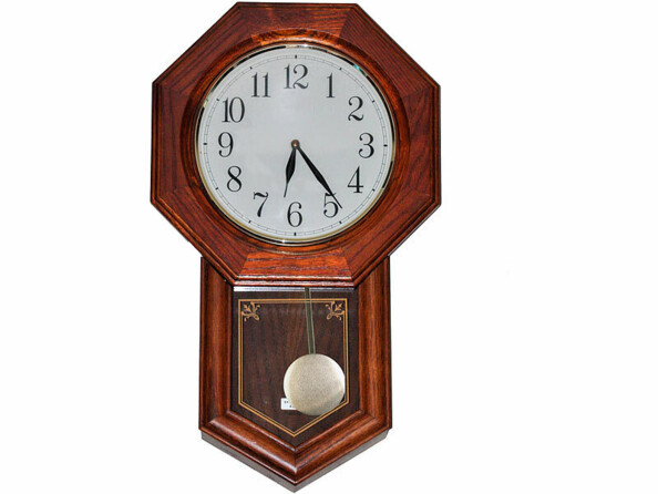 Mécanisme avec pendule intégré dans une horloge murale ancienne en bois massif avec pendule métallique et cadran analogique