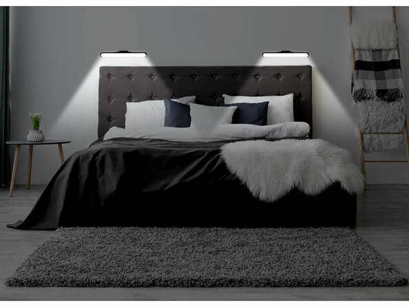 Lit avec draps coloris noir et blanc et tête de lit capitonnée éclairée par deux réglettes LED murales blanches