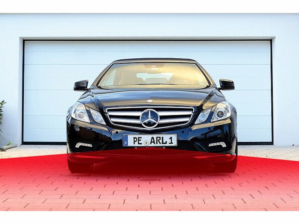 Illustration de l'angle de détection infrarouge de la caméra frontale placée sur la plaque d'immatriculation d'une mercedes garée devant un garage par le biais d'un faisceau rouge