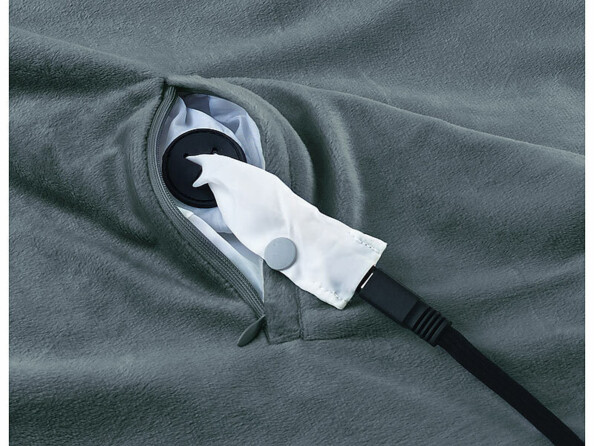 Gros plan sur l'ouverture de la poche pour raccordement du câble d'alimentation avec câble branché et couverture étalée à plat