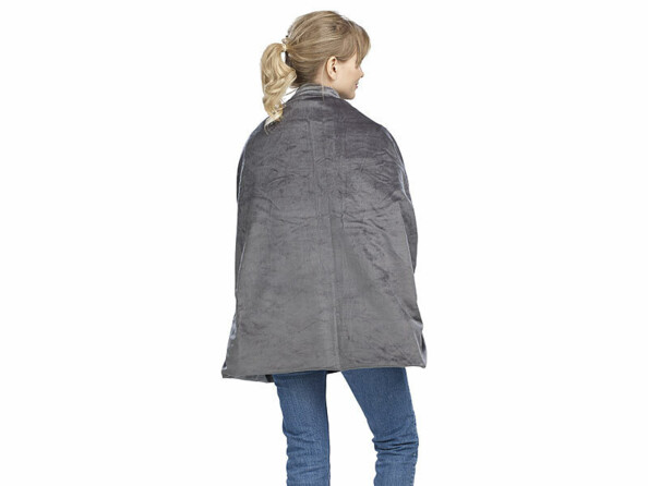 Femme blonde avec queue de cheval et jean portant sur ses épaules la couverture chauffante