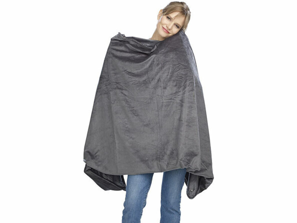 Jeune femme debout tenant devant elle le plaid chauffant