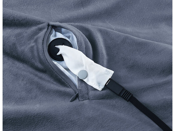 Gros plan sur l'ouverture de la poche pour raccordement du câble d'alimentation avec câble branché et couverture étalée à plat