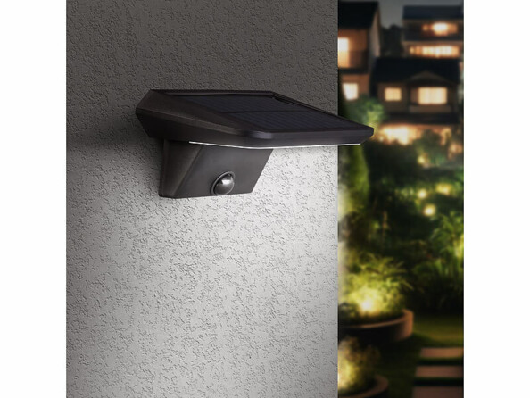 Lampe murale solaire éclairant la façade d'un bâtiment d'une lumière blanche